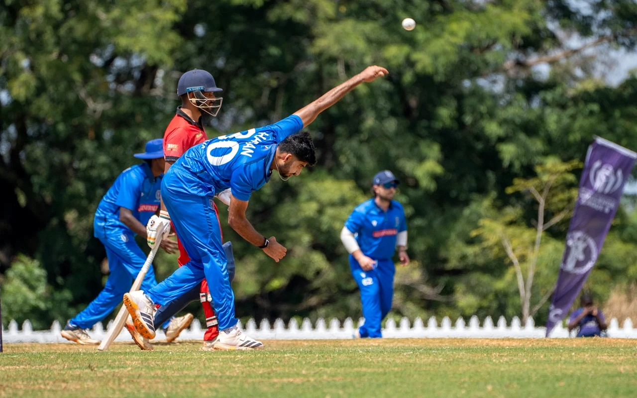 A fast bowler in his delivery stride during a match, showing the extension and rotation the lower back absorbs