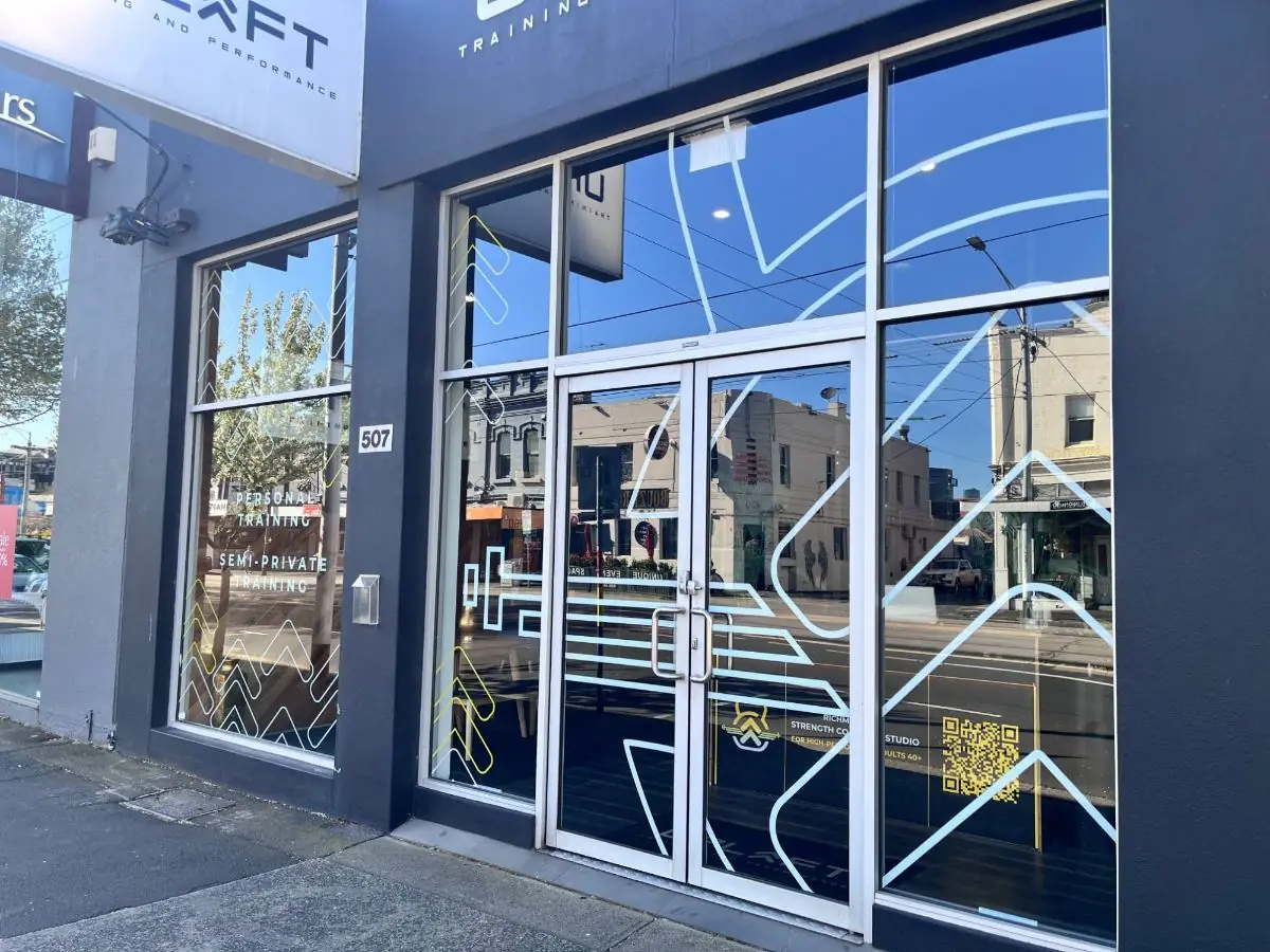 Glass double doors of Uplift Gym at 507 Bridge Road, Richmond, with the 507 street number on the pillar to the left