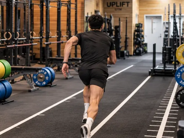 A runner sprinting on the indoor track at Uplift Gym in Richmond