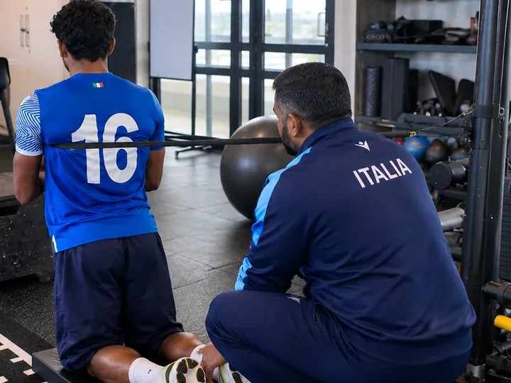 A physiotherapist guiding a person through a resistance band exercise in a rehabilitation session