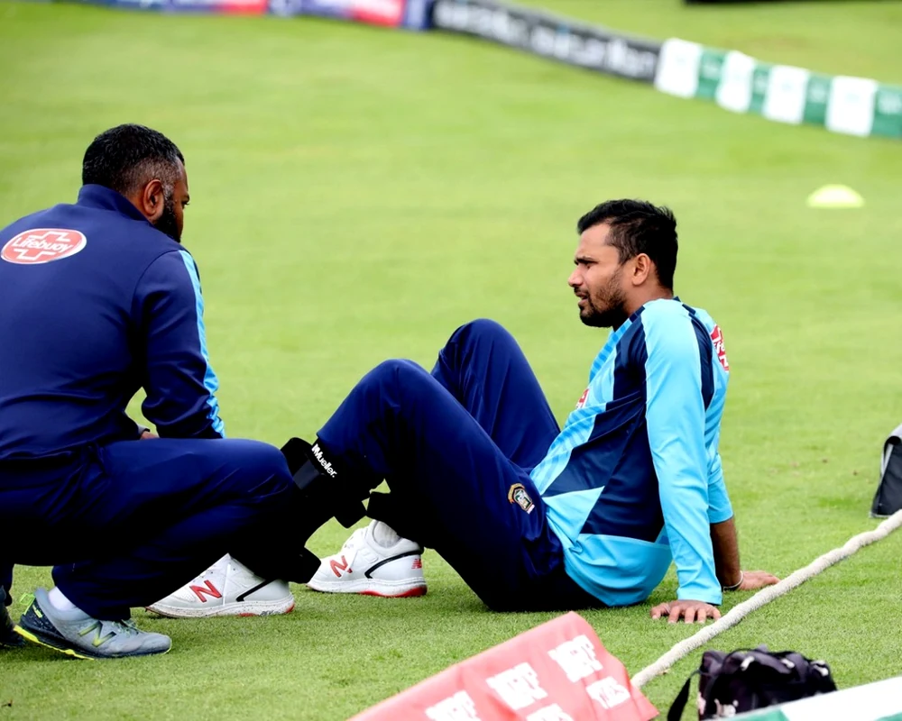 Thihan Chandramohan assessing an international cricketer's knee at a training ground